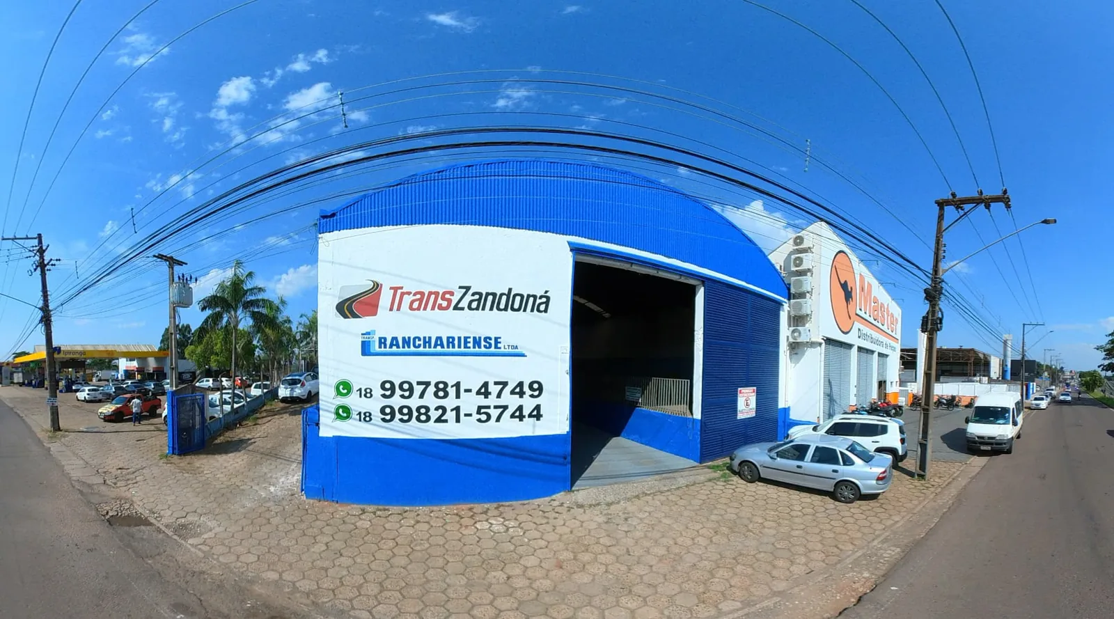 Fachada da unidade TransZandoná em Presidente Prudente-SP, galpão com cobertura em arco azul e placa com a marca — telefone (18) 99795-2196