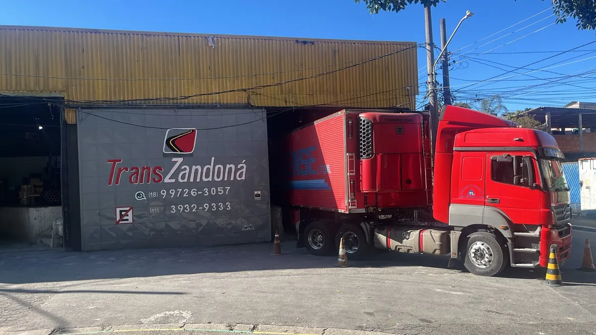 Fachada da unidade TransZandoná em São Paulo com caminhão refrigerado (Thermo King) no pátio — telefones (18) 99726-3057 e (11) 3932-9333